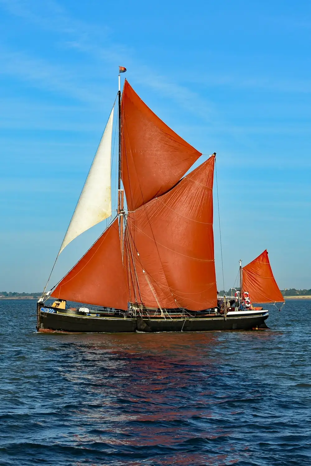 A Thames sailing barge with red sails