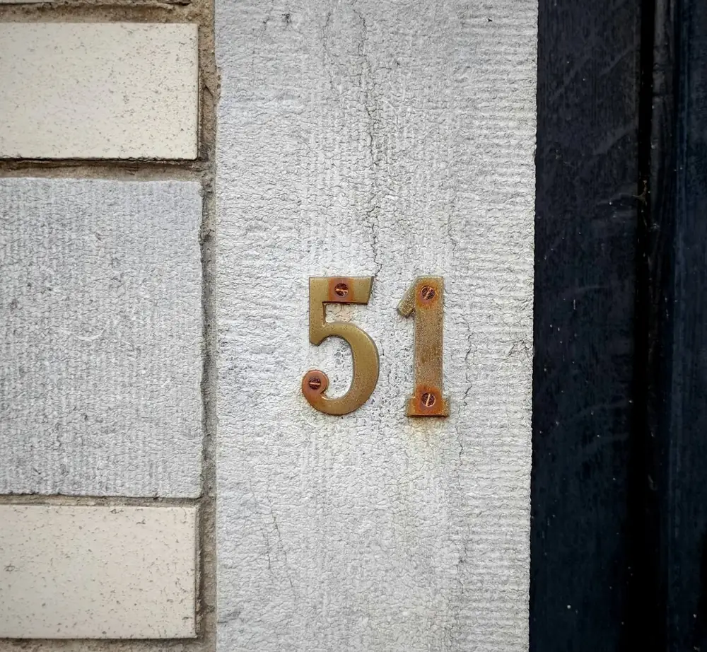 Brass door numerals on stone