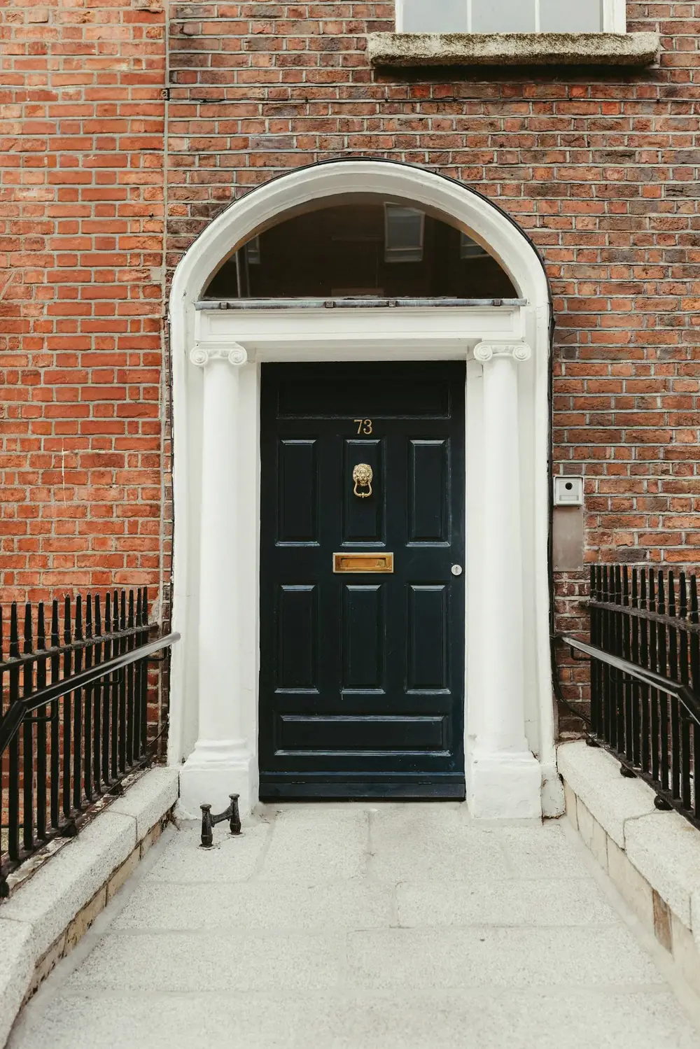 A black front door in a red brick facade