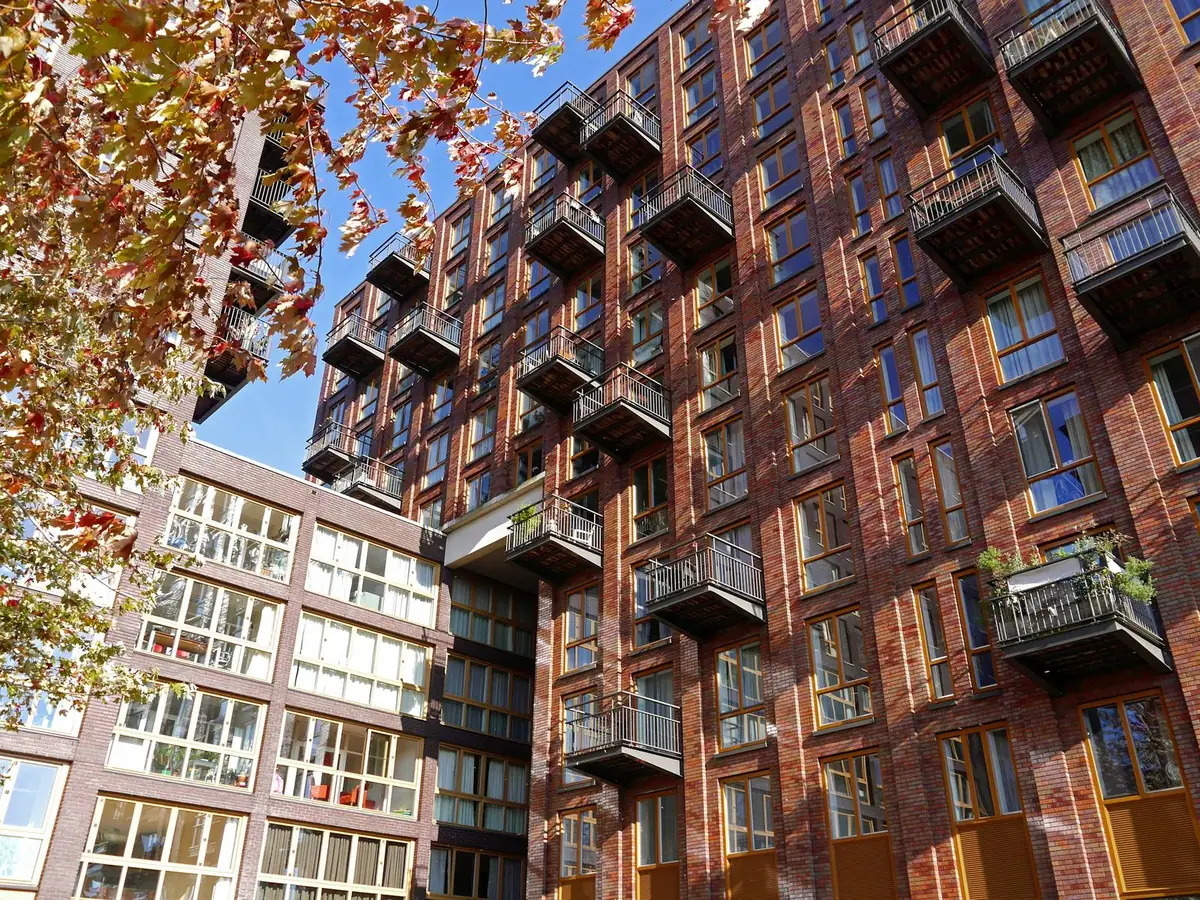 Brick apartment blocks with balconies among trees